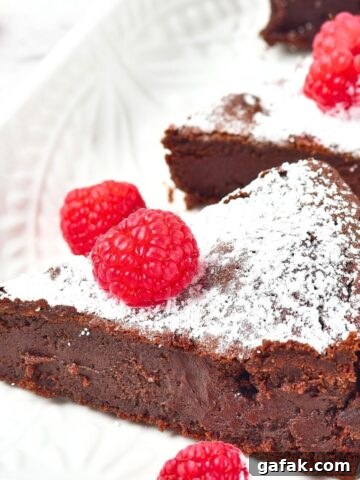 Slices of flourless chocolate cake on white plate