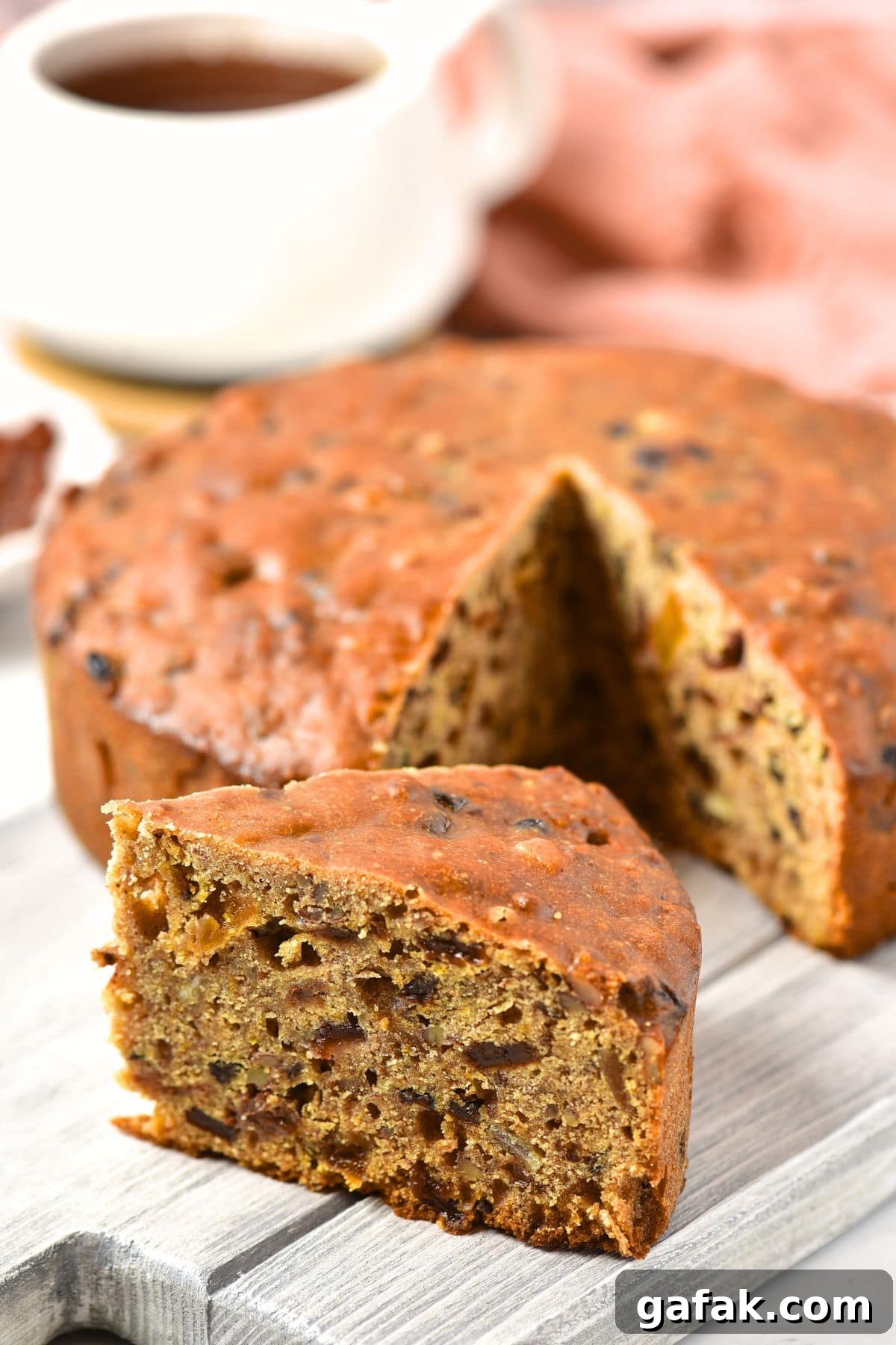 Gluten Dairy-Free Fruit Cake Up close view of a slice of gluten-free fruit cake on grey board.