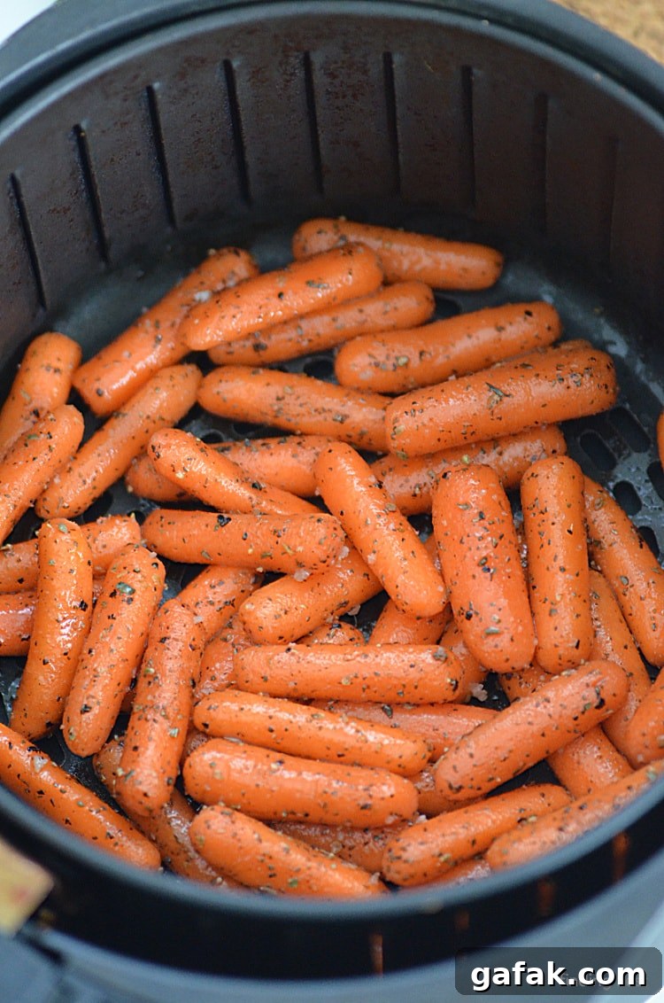 Crispy Air Fryer Baby Carrots Recipe for Quick Side Dish 7 Roasted carrots in an air fryer basket ready to be cooked