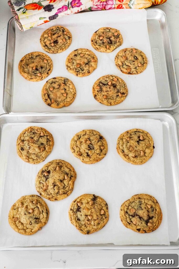 Baked caramel chocolate chip cookies on a baking sheet.