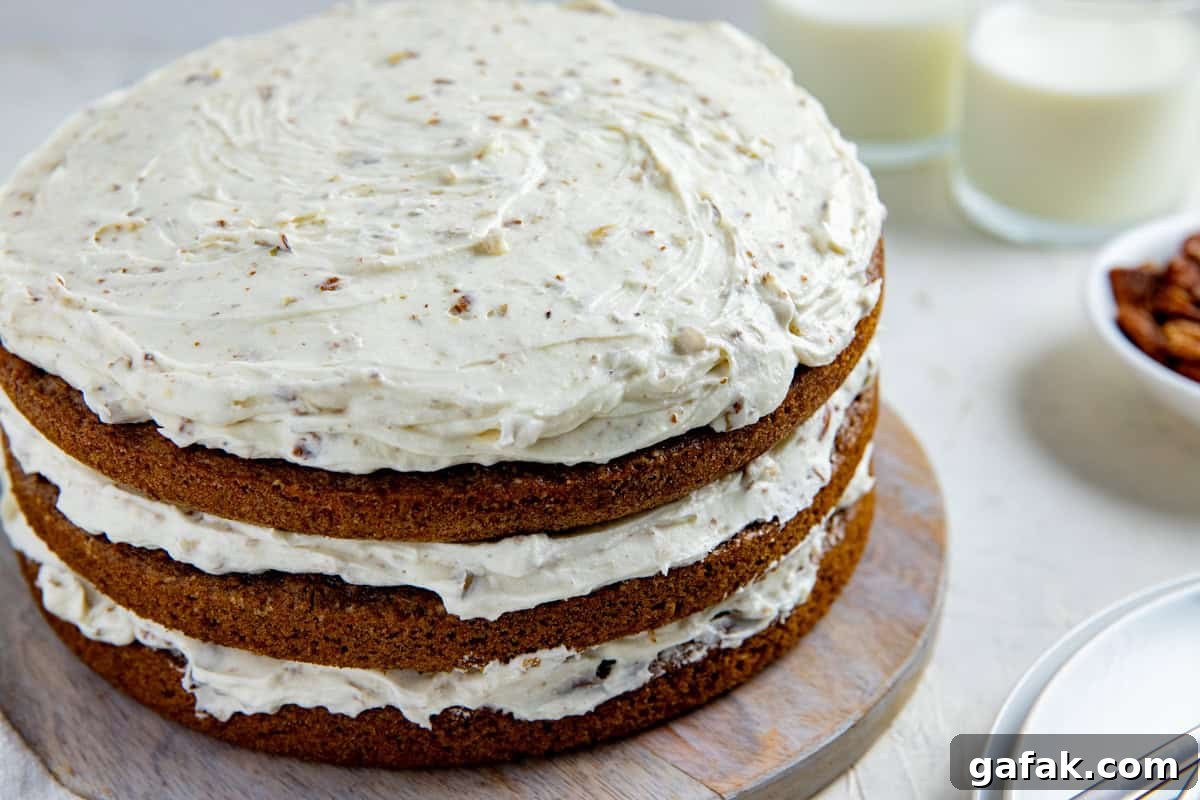 Frosted 3-layer carrot cake on round wooden cake platter.