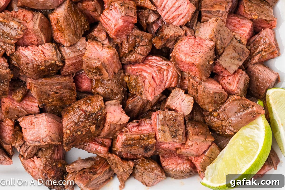 Chipotle Steak Recipe: Smoky Grilled Steak with Chili-Lime Rub 2 Chipotle Steak Bites on a platter with a lime wedge on the side