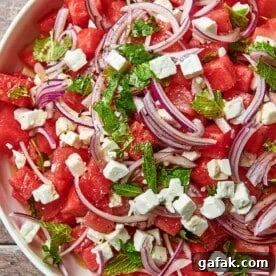 Watermelon Feta Salad in white serving dish on wood table.