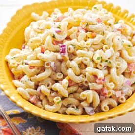 Old-fashioned macaroni salad in yellow bowl on table.