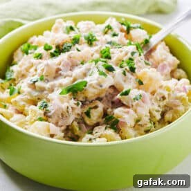 Spoon in a green bowl filled with potato salad.