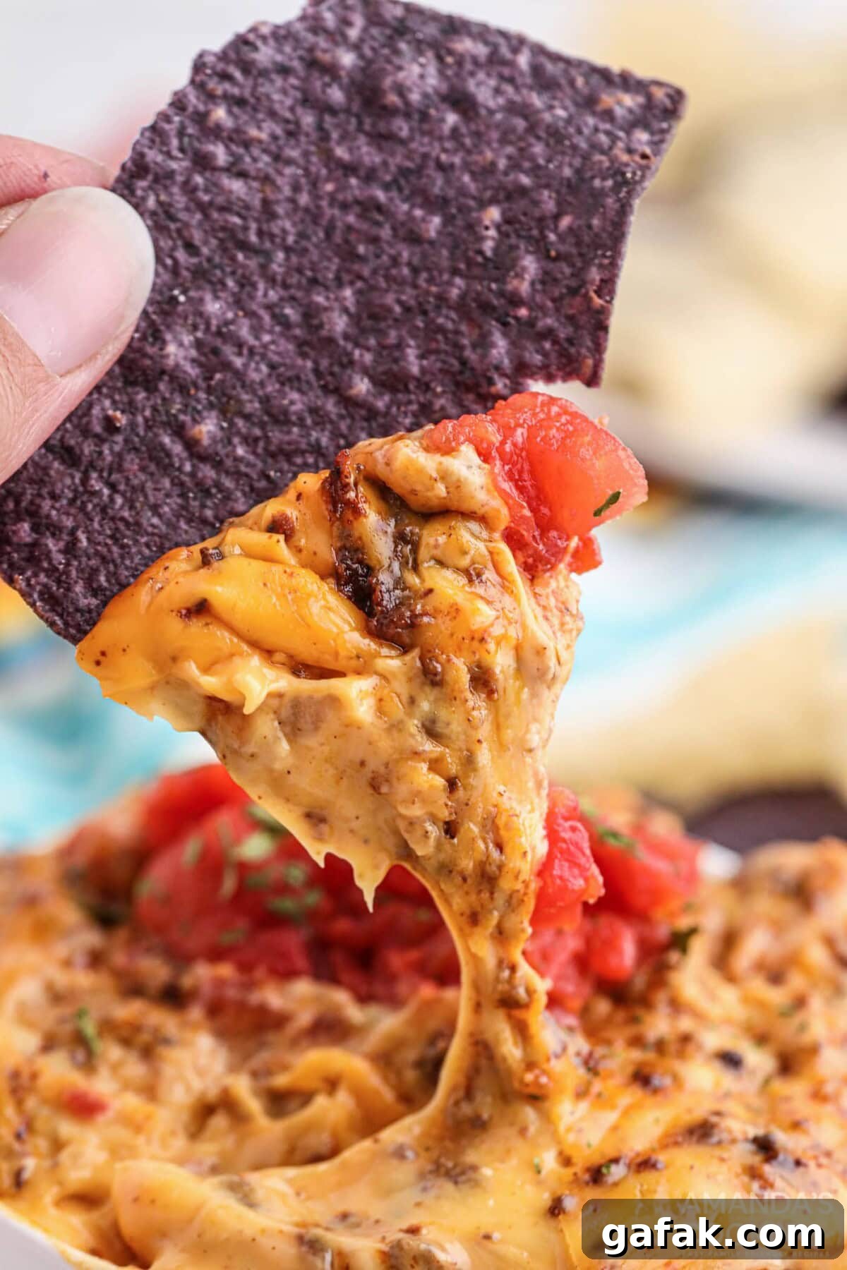 dipping chip into Smoked Queso Dip