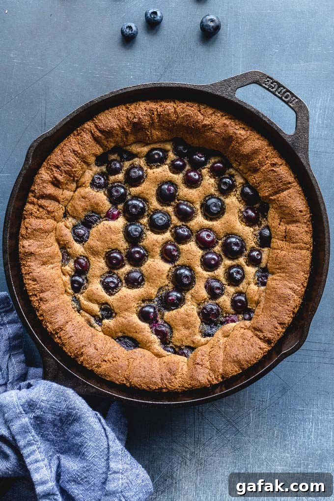 Gluten-free skillet cookie with blueberries baked into the top.