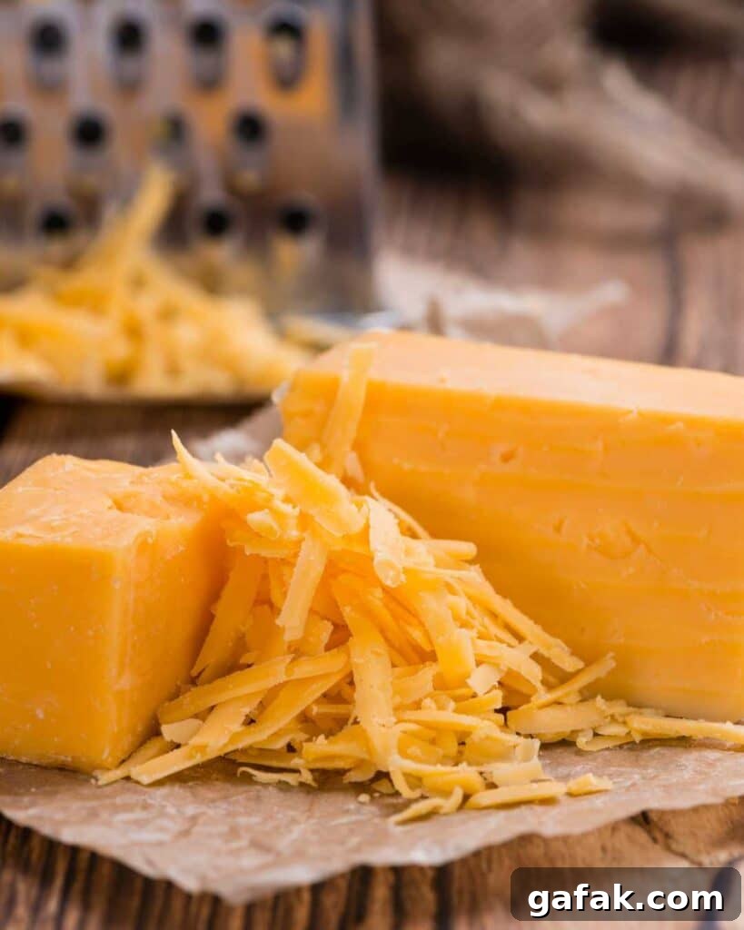 Shredded cheddar cheese in between two blocks of cheese.