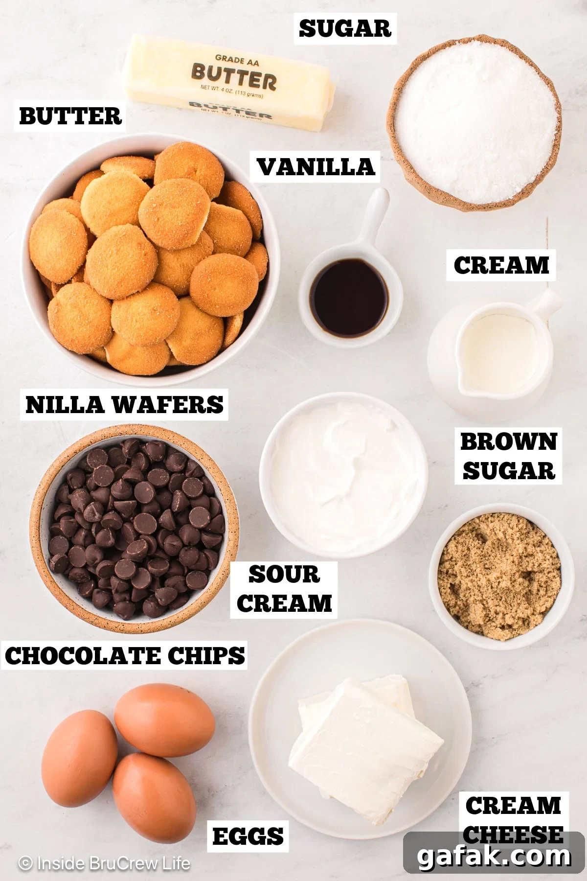 Creamy No-Bake Cheesecake Bars Recipe for Parties 3 A white board with bowls of ingredients needed to make a 9x13 cheesecake.