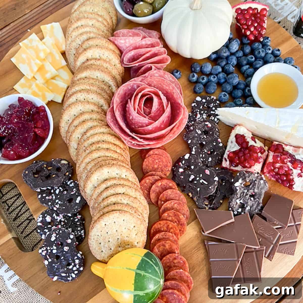charcuterie board filled with fruit, crackers, meat, chocolate, cheese, etc.