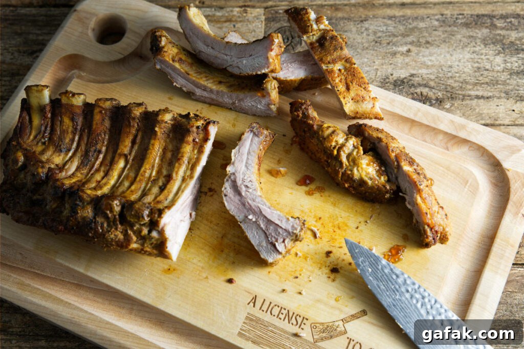 Cutting up slab of pork ribs on cutting board.