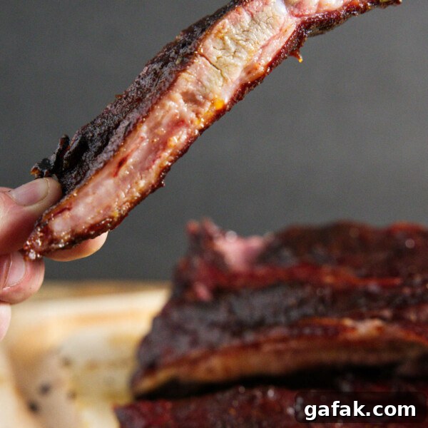 traeger smoked pork spare ribs, sliced and one being held