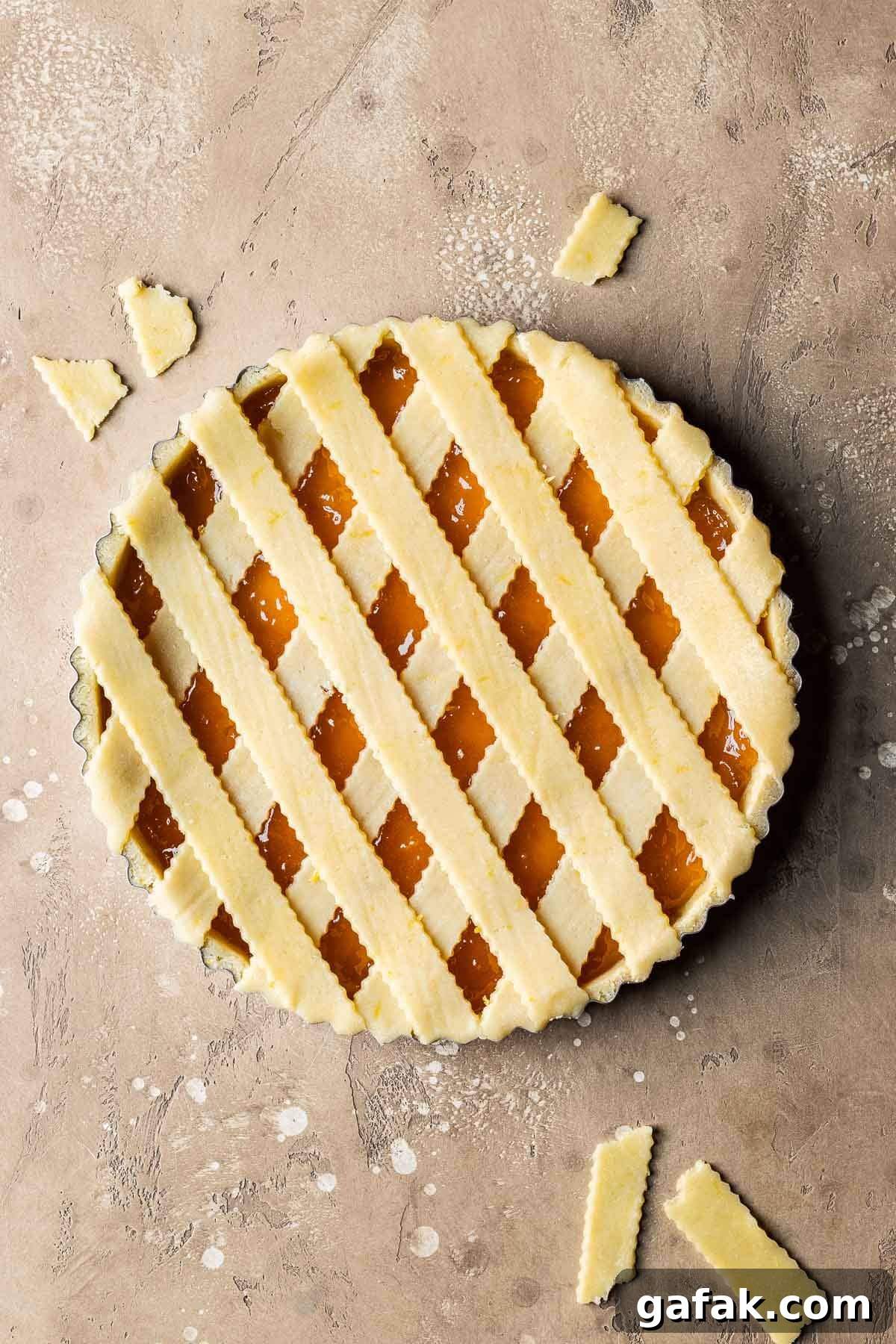 An unbaked crostata di marmellata with strips of lattice dough on top.