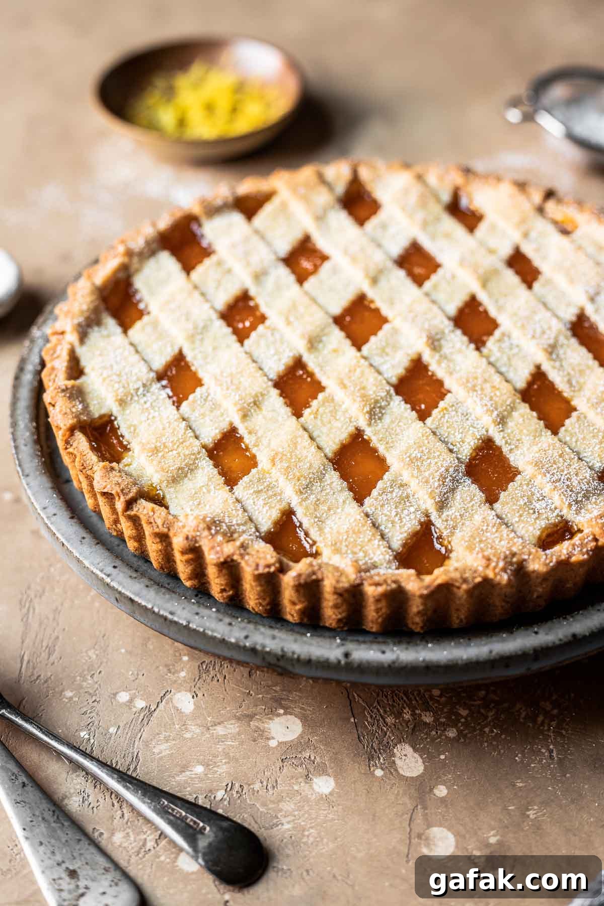 A lattice topped crostata di marmellata on a plate.