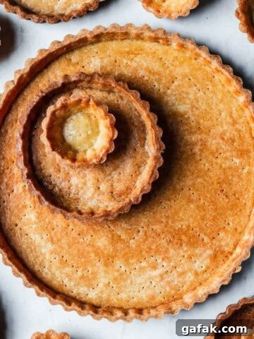 Golden brown baked tart shells in tartlet, mini and large sizes.