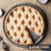 A lattice topped crostata di marmellata with one slice removed.