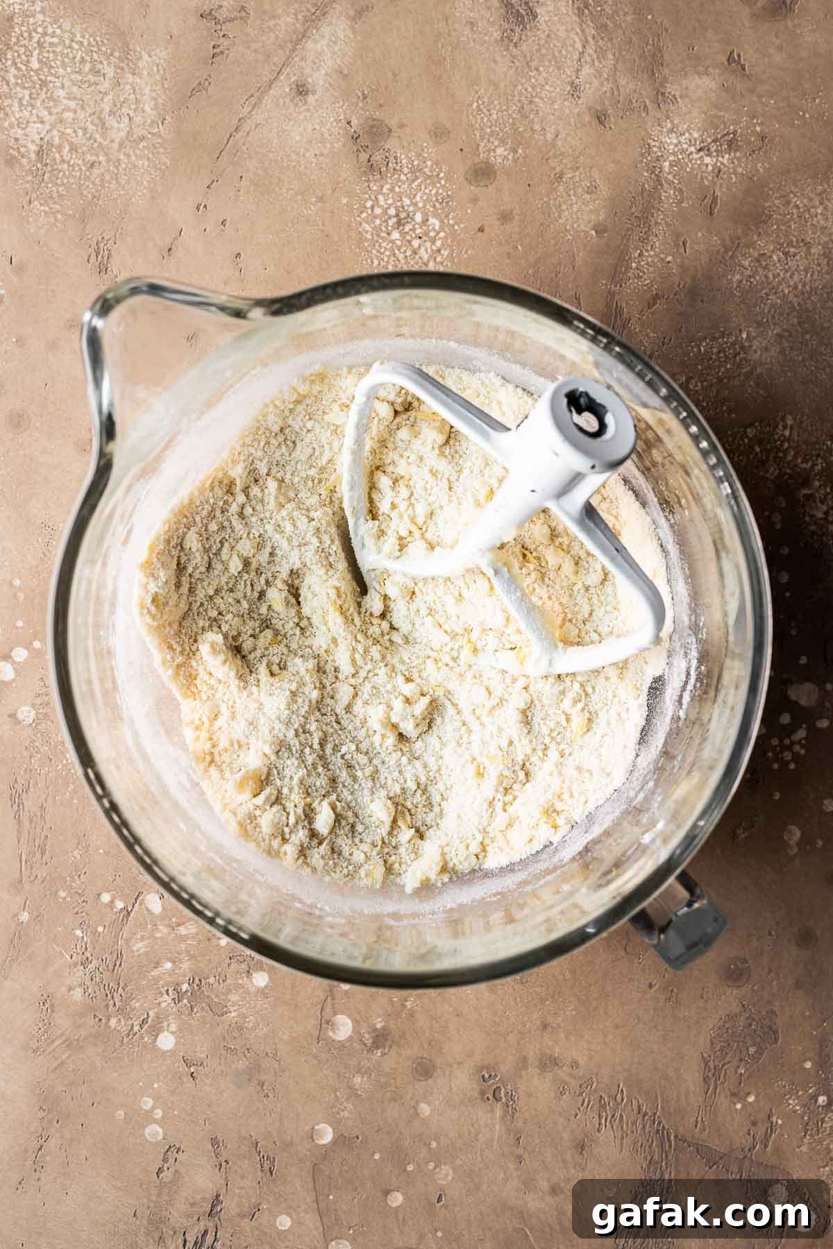Dry and wet ingredients for tart dough in a clear glass mixing bowl.
