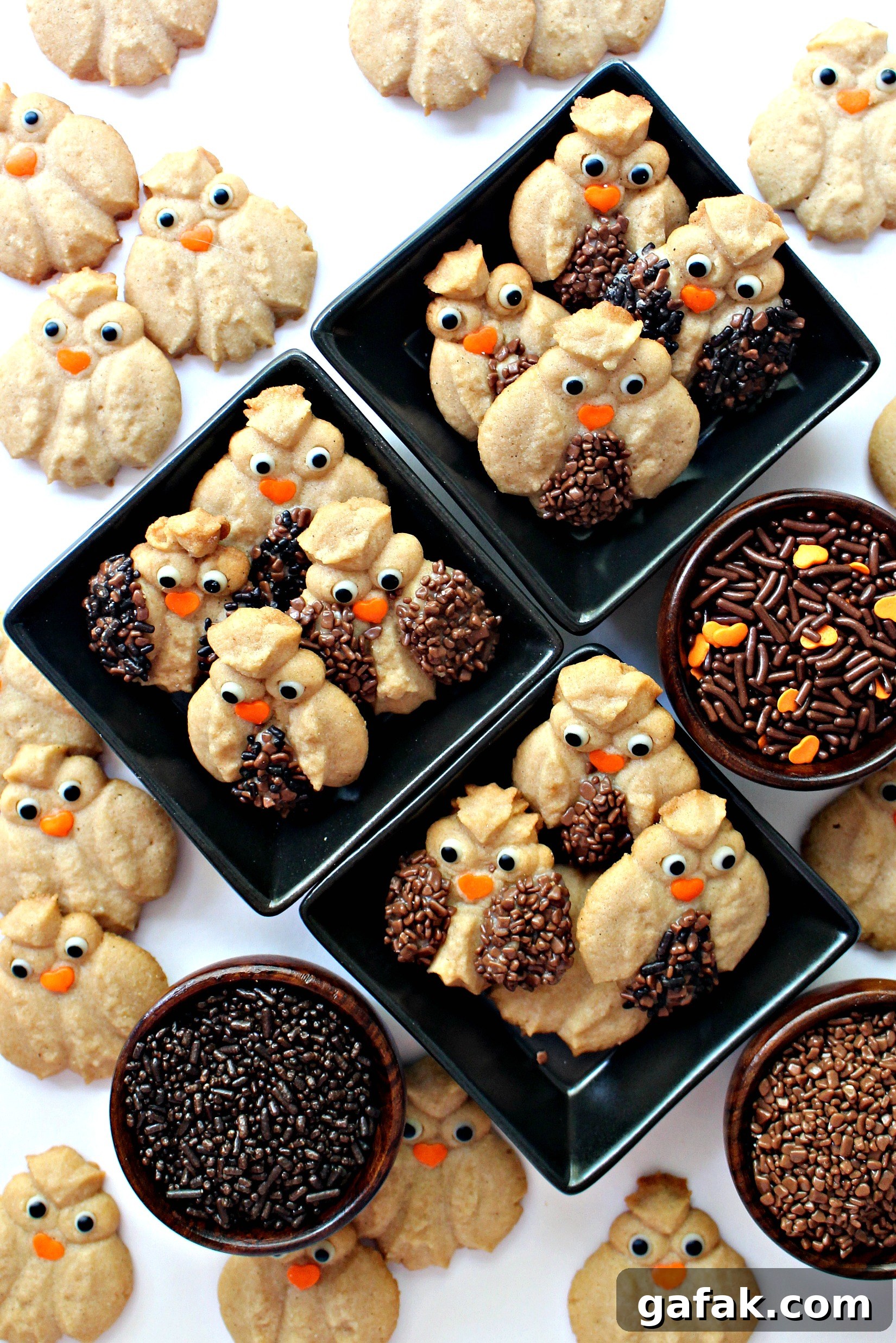 Cinnamon Spritz Owl Cookies are buttery cookies warmed with cinnamon and baked until crisp. A cookie press easily makes dozens of owls in minutes! | themondaybox.com Cinnamon Spritz Owl Cookies with added chocolate sprinkles feathers, candy eyes, and orange sprinkle beaks.