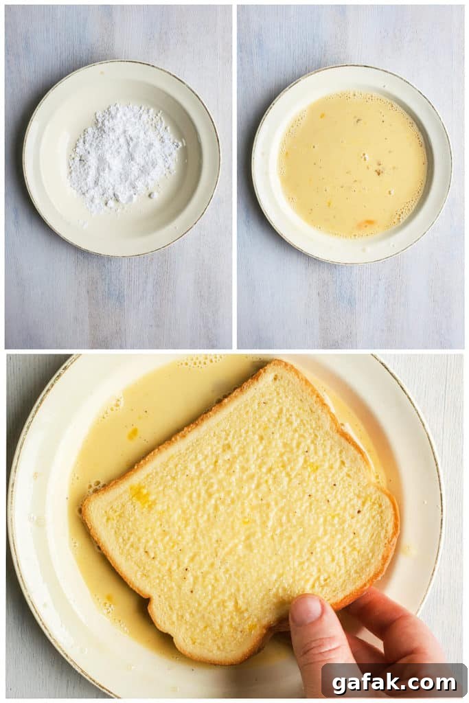 Hand dipping french toast in egg mixture in a white bowl.