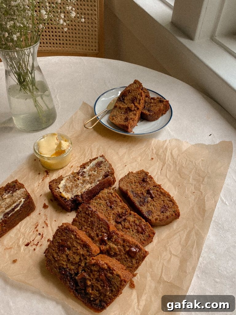 Gluten-Free Dairy-Free Zucchini Bread Recipe 3 sliced zucchini bread on parchment paper and on a plate with small bowl of butter
