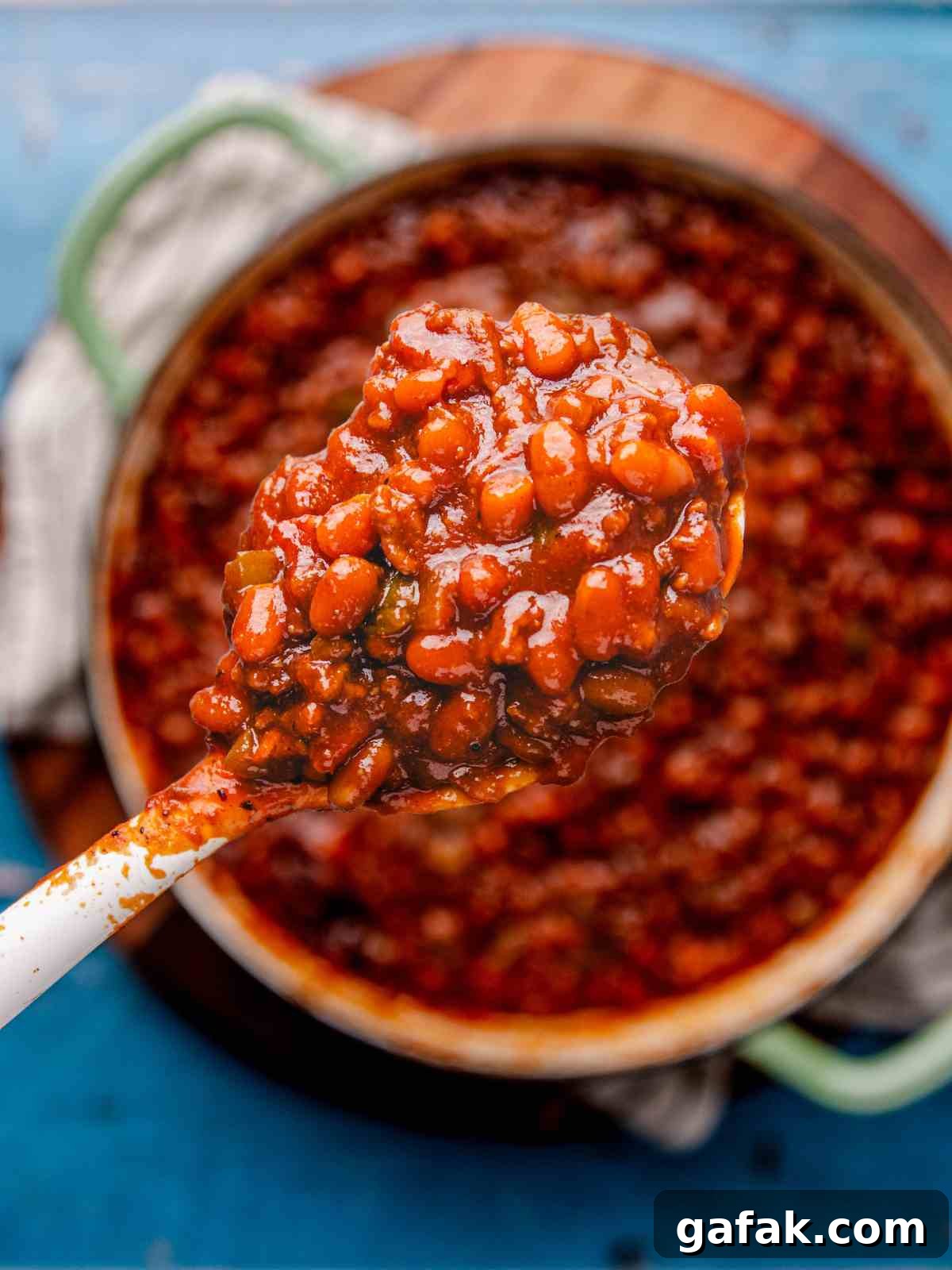 Savory Baked Beans with Seasoned Ground Beef Recipe 4 A scoop of baked beans in a spoon.