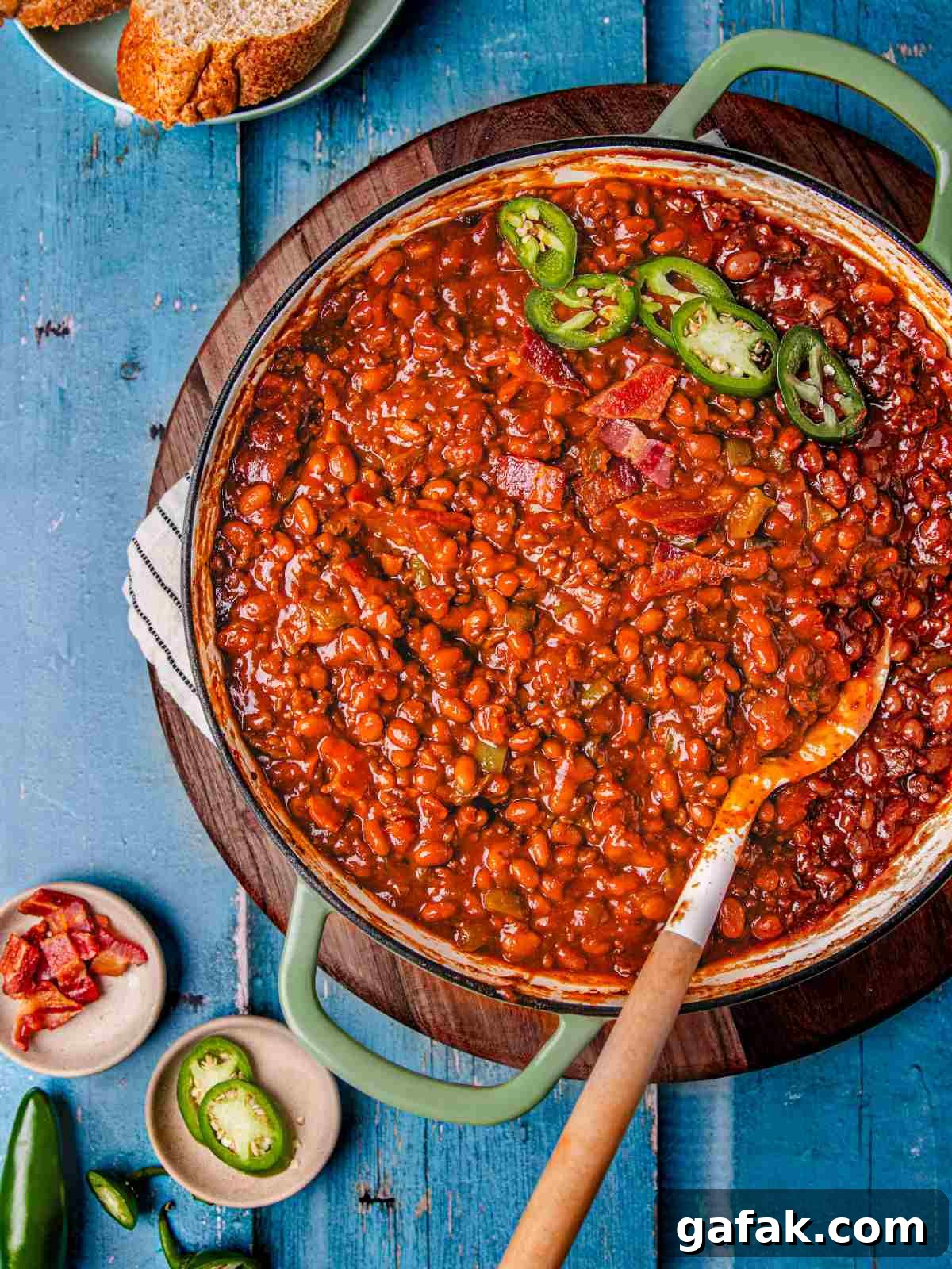 Savory Baked Beans with Seasoned Ground Beef Recipe 8 one pot beans casserole in a skillet garnished with jalapenos and bacon.