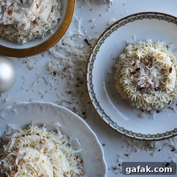 Several plates of mini coconut cakes with maple Italian meringue buttercream.