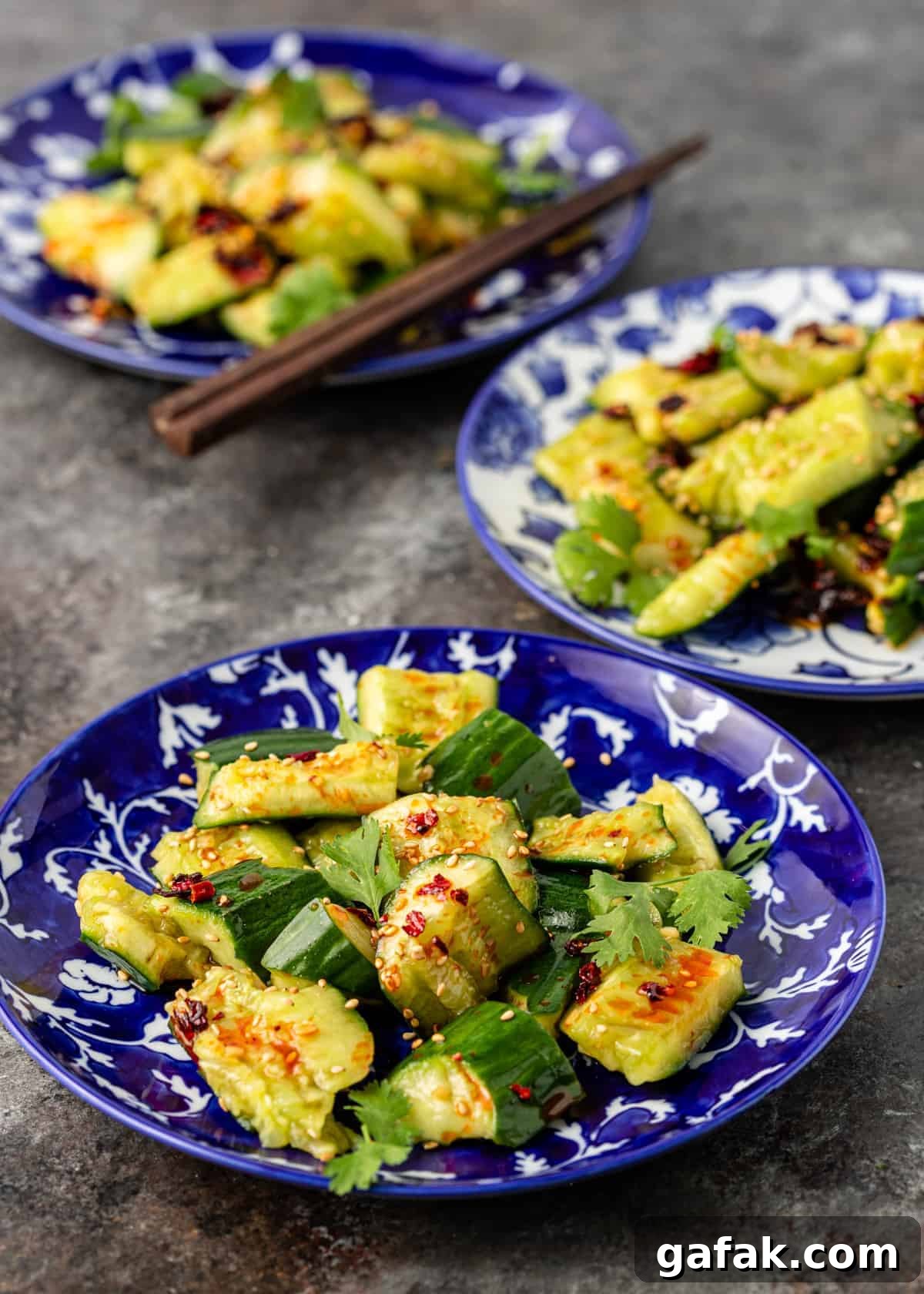 3 serving bowls of huang gua cucumber salad lined up front to back