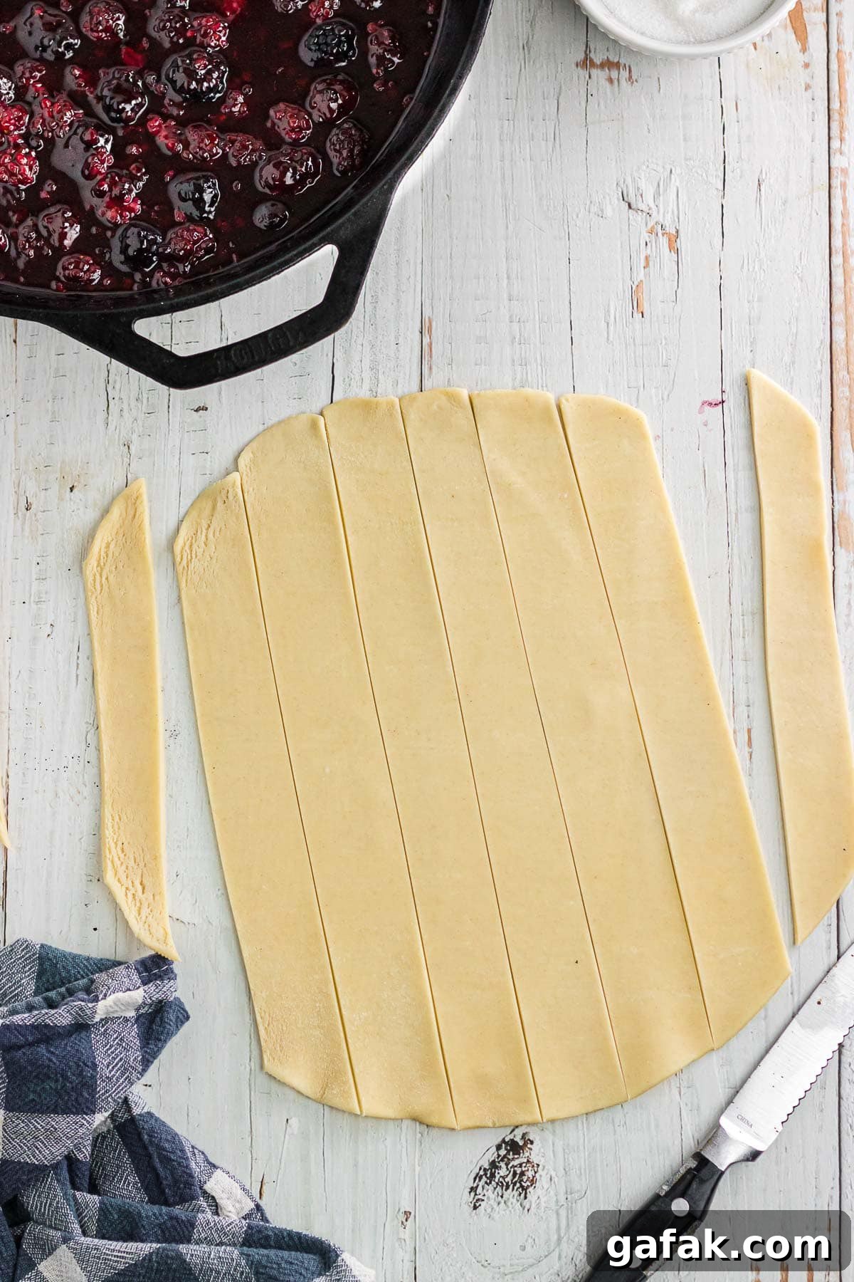 The pie crust dough rolled out and cut into strips.