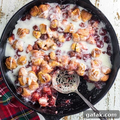 Overhead view of a finished cherry and cream cheese coffee cake with vanilla glaze.