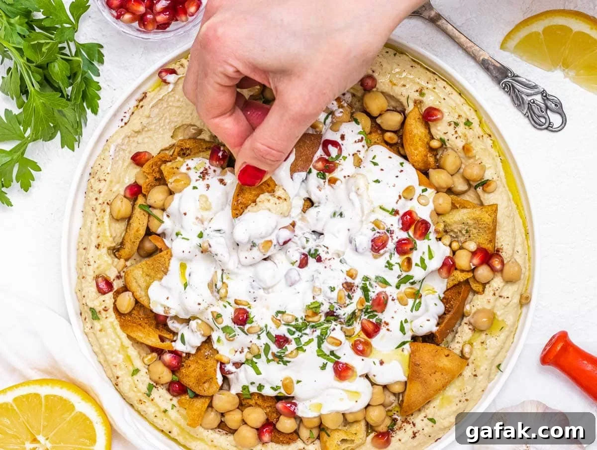 Fatteh with Pita, Hummus, and Creamy Yogurt Bowl 3 Fatteh with hand and red nails