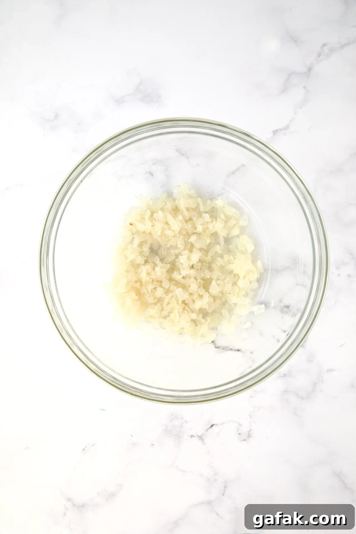 Half of the cooked onions in glass bowl.