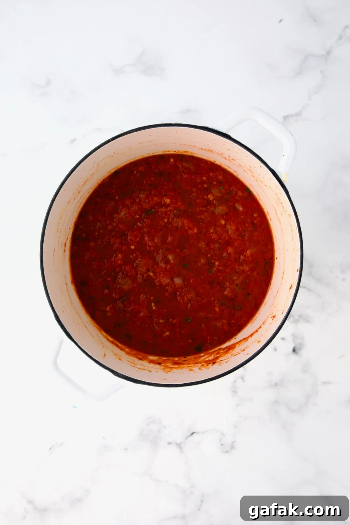Tomato sauce in white Dutch oven.