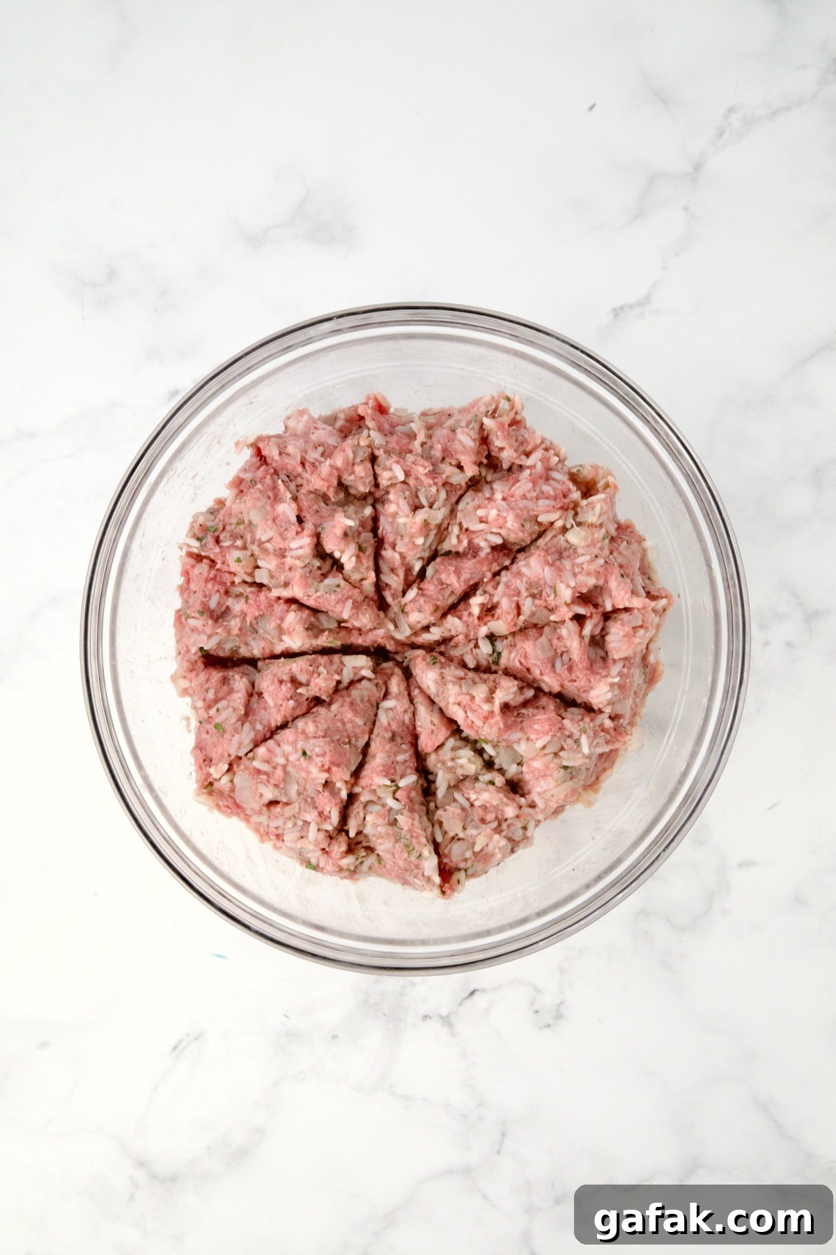 Filling for cabbage rolls in glass bowl divided into 12 sections.