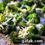 Close up of roasted broccoli on a baking sheet.
