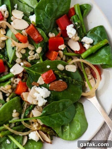 Spinach, asparagus and red pepper salad on a plate.