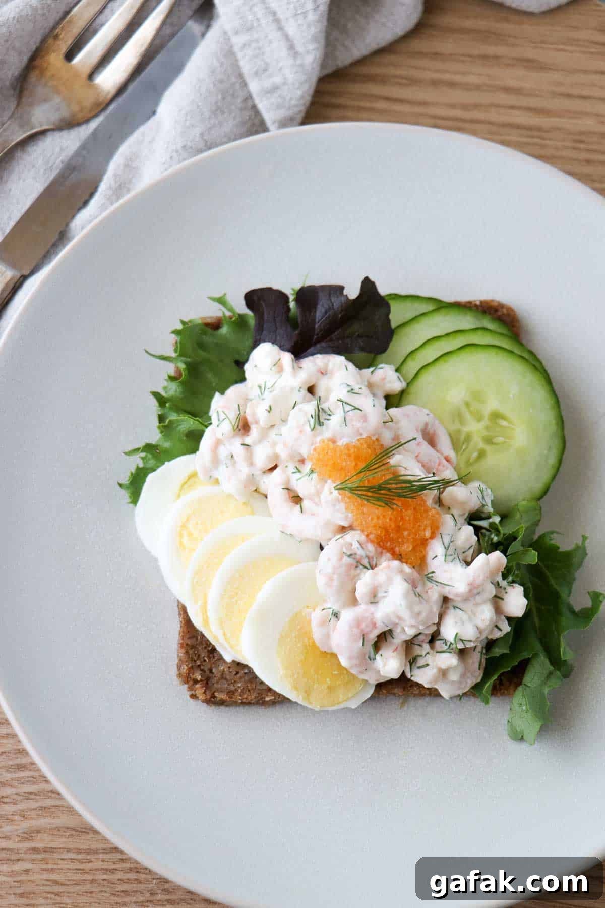 Skagenröra (Swedish Shrimp Salad) on rye bread with sliced hard boiled egg, cucumber and caviar.