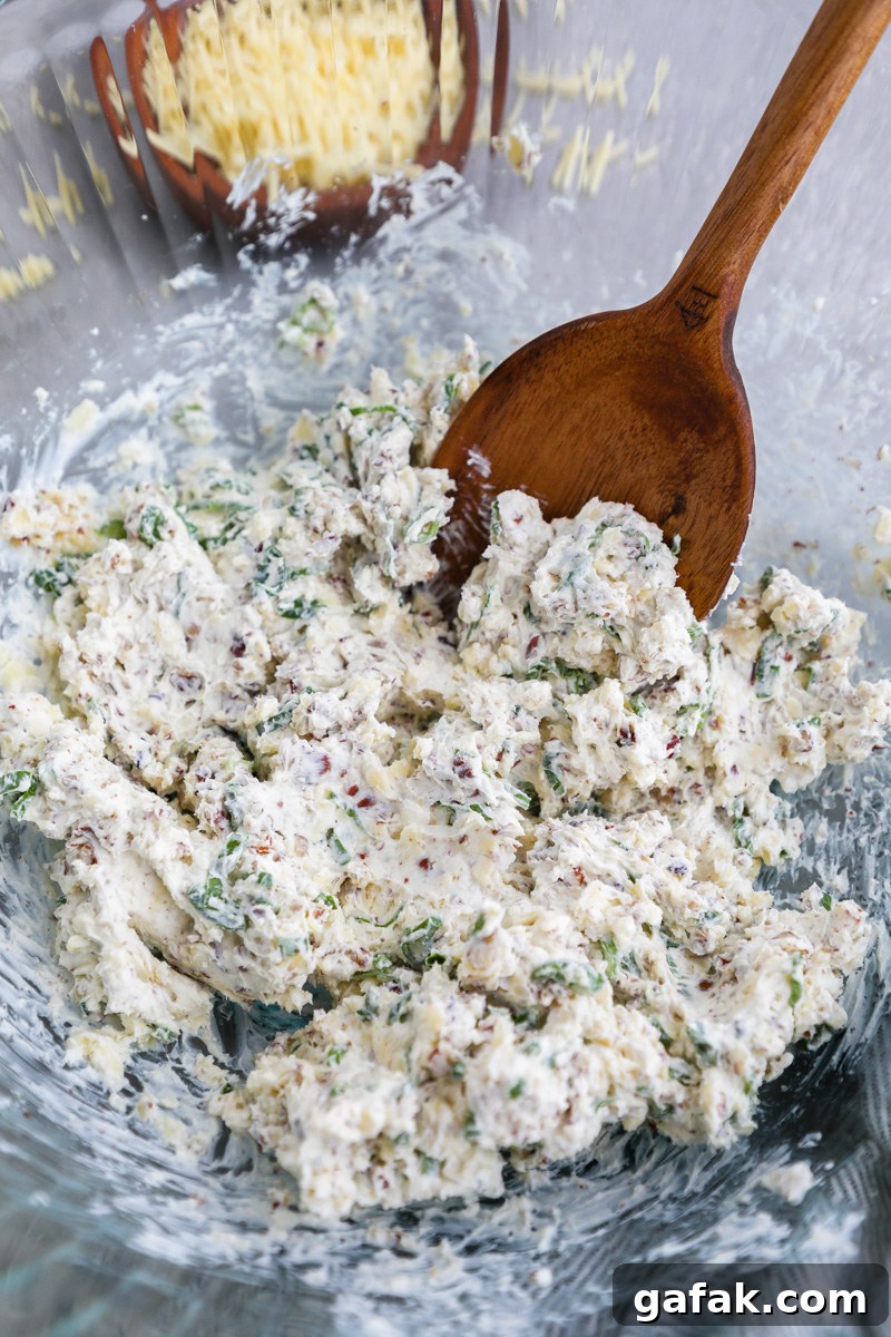 A large mixing bowl filled with a white cheddar cheese ball mixture