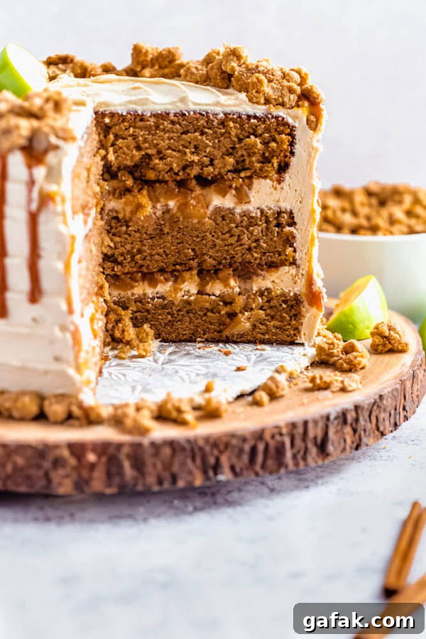 caramel apple crumble cake cut open on a wooden cake stand