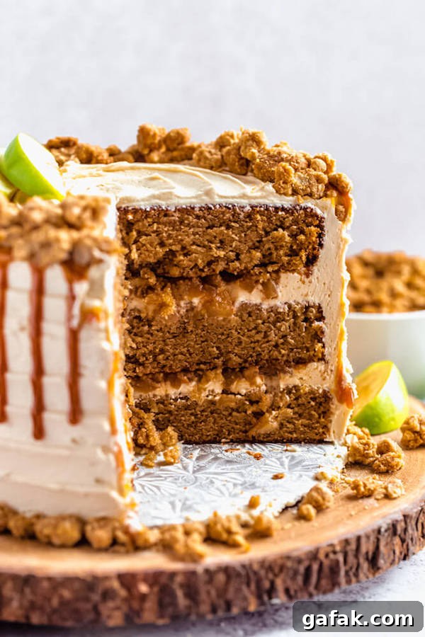 caramel apple crumble cake cut open on a wooden cake stand
