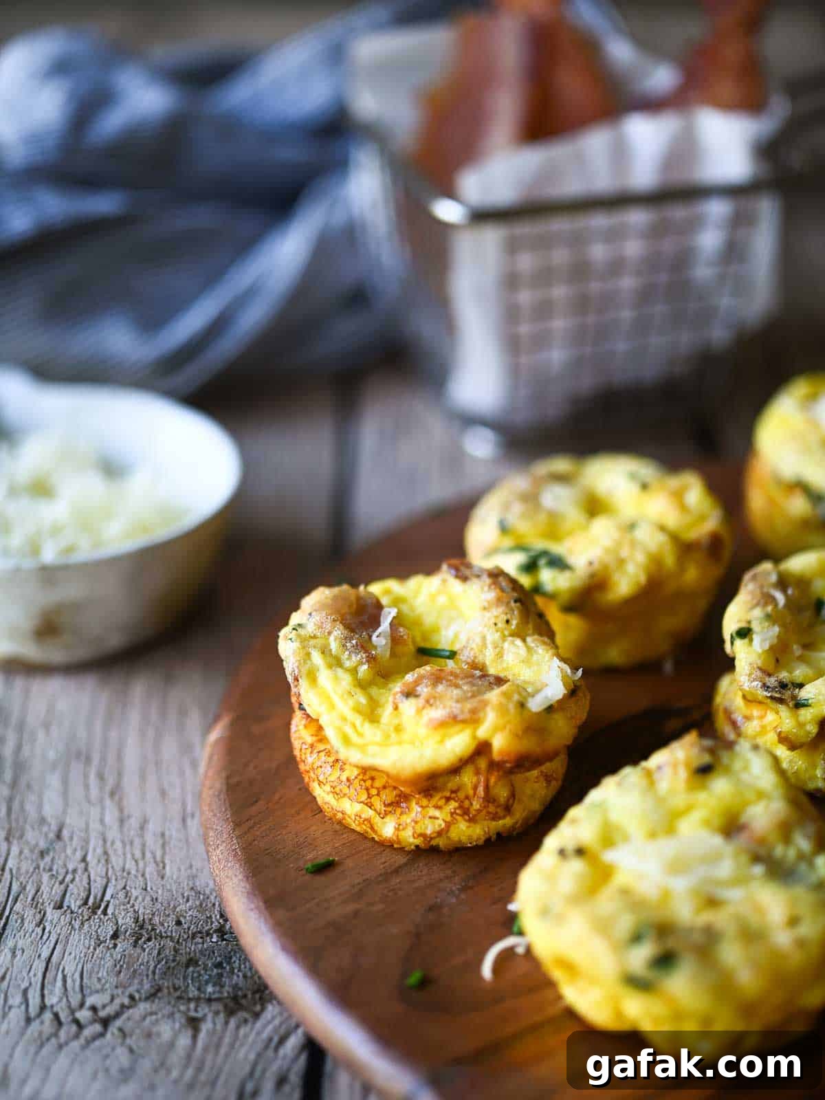 Egg bites on a wood board with bacon and cheese.