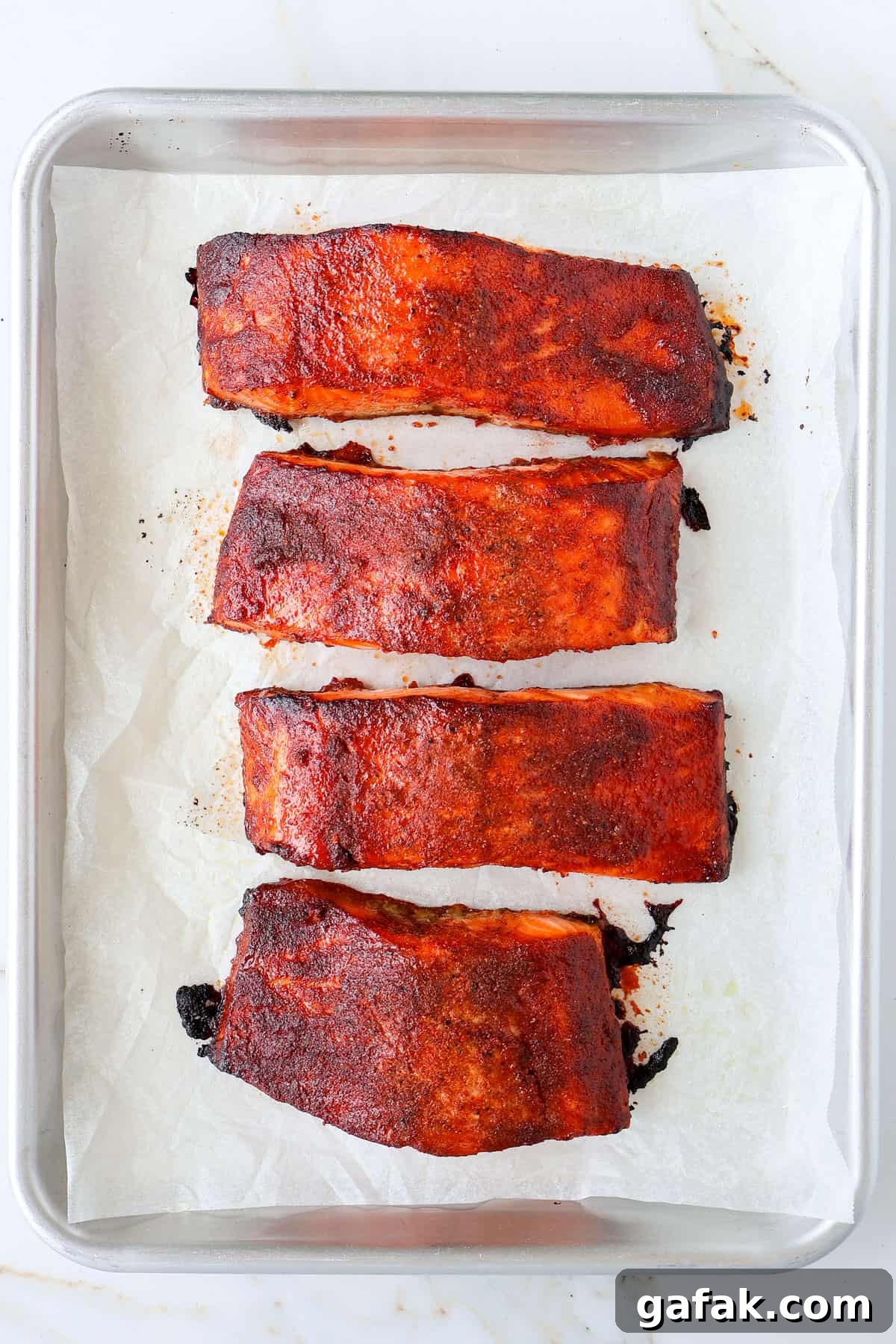 Grilled honey paprika salmon filets on a baking sheet.