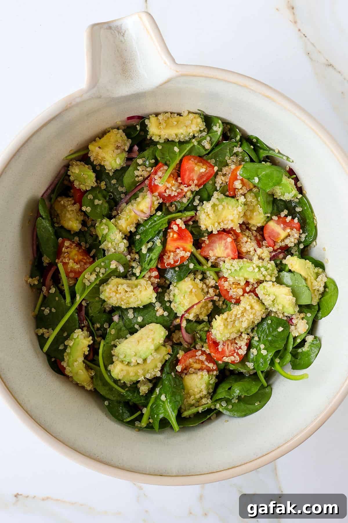 Avocado quinoa salad in a mixing bowl.