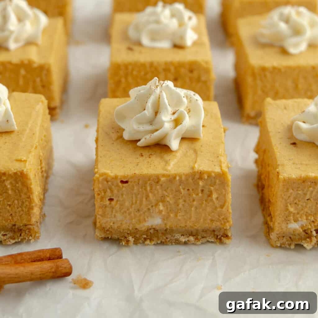 Mini Pumpkin Hand Pies: Flaky Autumn Pastry Recipe 21 Up close pumpkin cheesecake bar with other cheesecake squares topped with whipped cream.