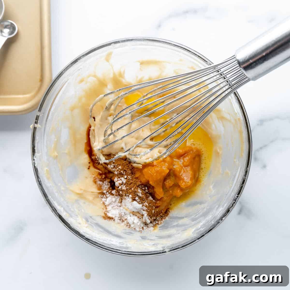 Mini Pumpkin Hand Pies: Flaky Autumn Pastry Recipe 7 pumpkin, spices, and flour added to cream cheese filling in a clear bowl with a whisk.