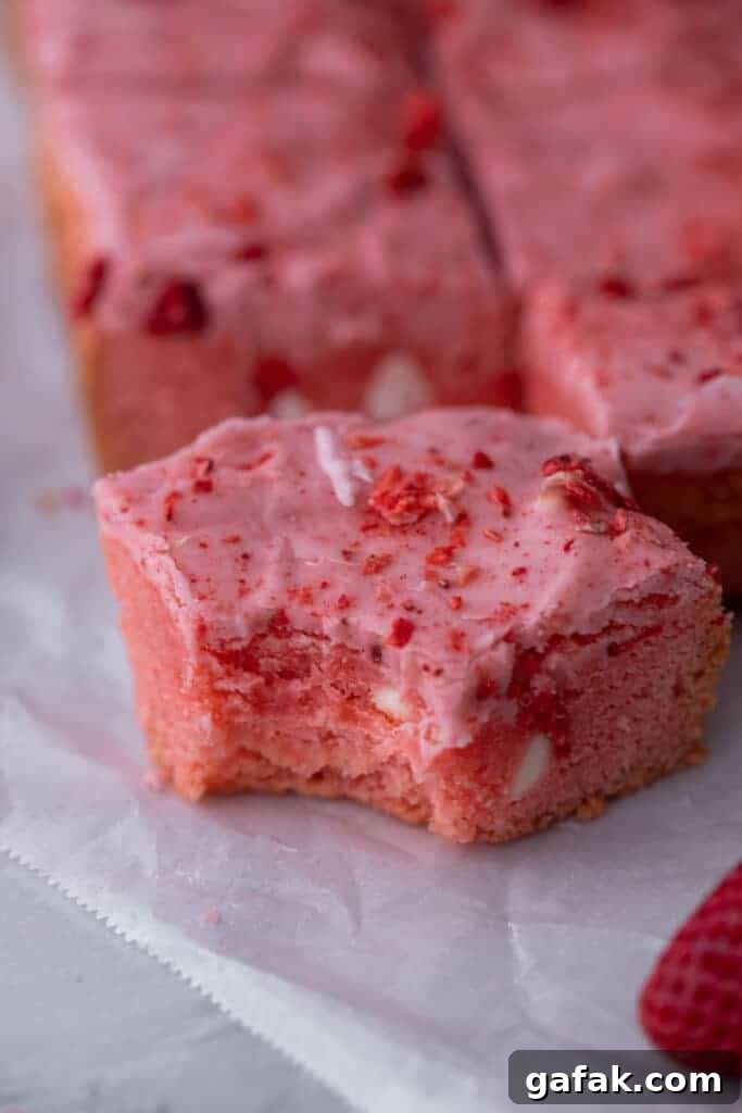 Strawberry brownie topped with pink glaze and freeze-dried strawberries
