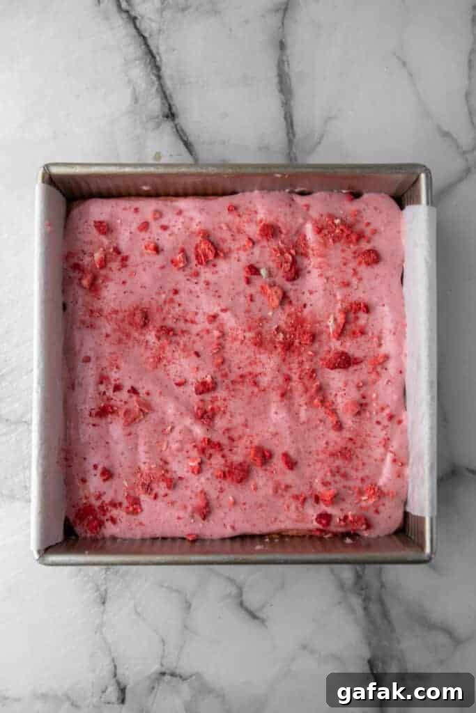 Baked and iced  strawberry brownies in a pan before slicing