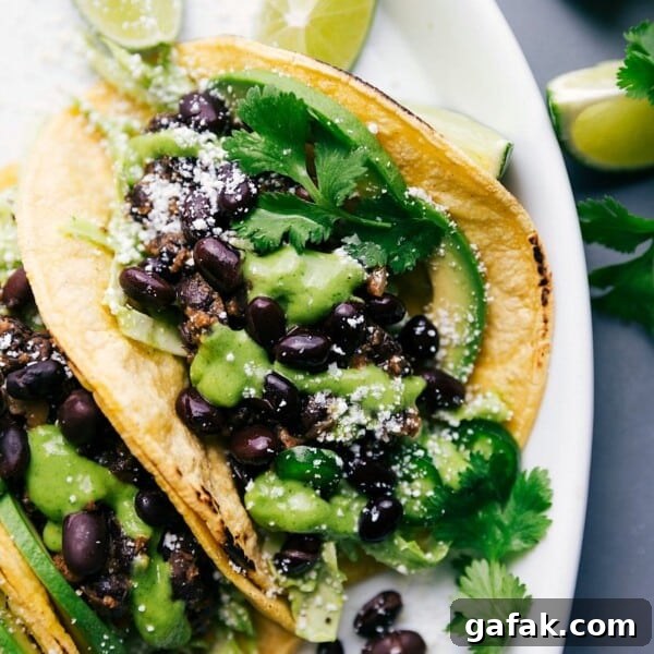 Black bean tacos with cilantro sauce and limes, ready to eat.