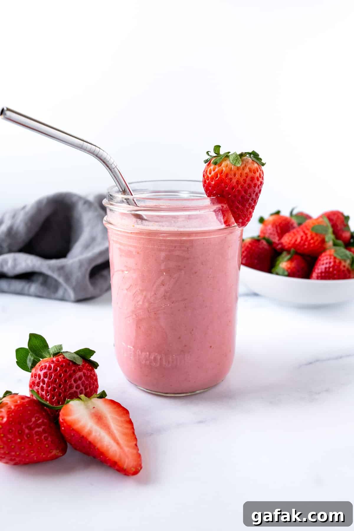 Strawberry Smoothie with Almond Milk in a glass with a metal straw.