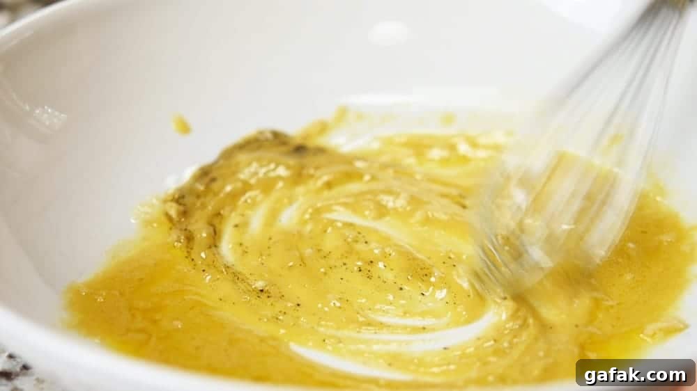 whisking dressing in the bottom of a large bowl